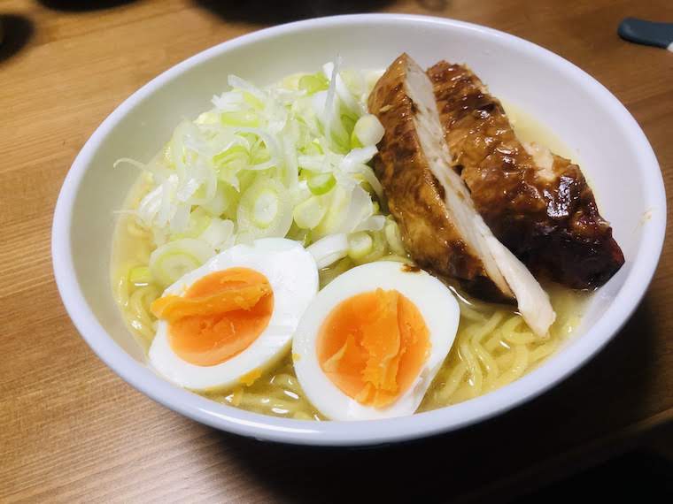 Chicken paitan ramen with roasted chicken, boiled eggs and green onions as toppings