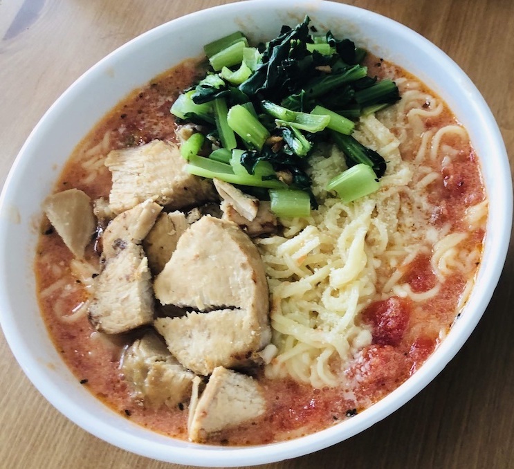 Tomato Ramen with chicken and spinach as toppings