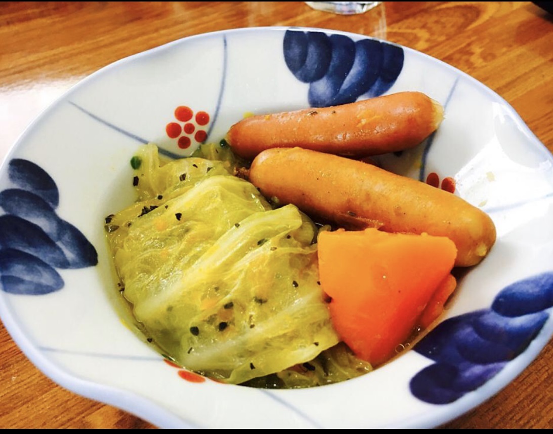 Cooked ground meat wrapped by cabbage leaves. Served with cooked weiner and carrots.